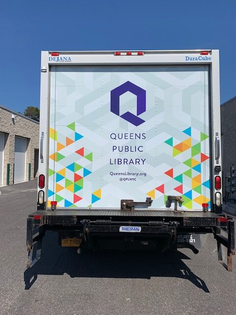 Box truck rear door with geometric vinyl wrap graphic and printed branding.