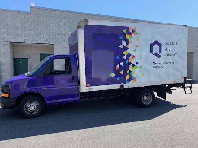 Purple box truck with large geometric vinyl wrap graphic on cargo panel.