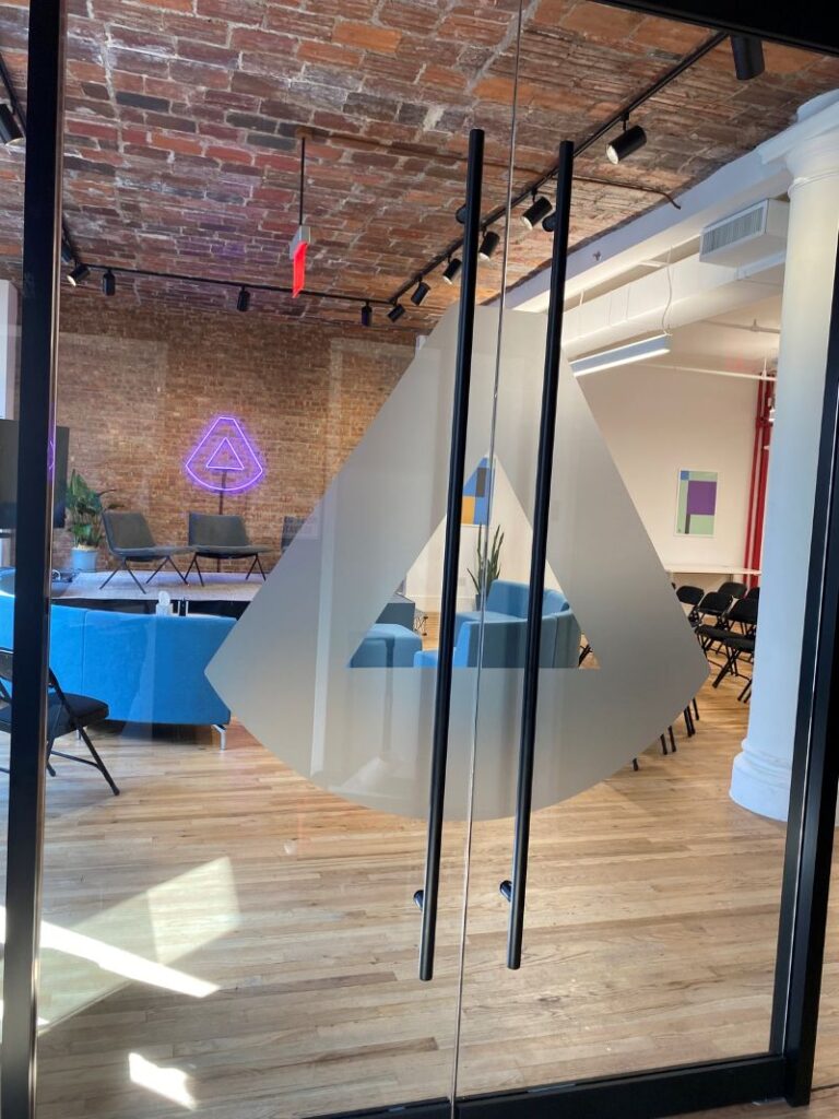 Glass office doors with large frosted geometric vinyl graphic panels.
