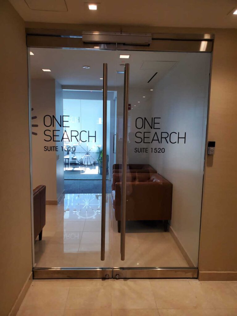 Glass office entrance doors with frosted vinyl lettering graphics.