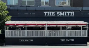 Exterior contour-cut vinyl lettering on a Manhattan restaurant storefront with high-contrast lettering visible from across the street.